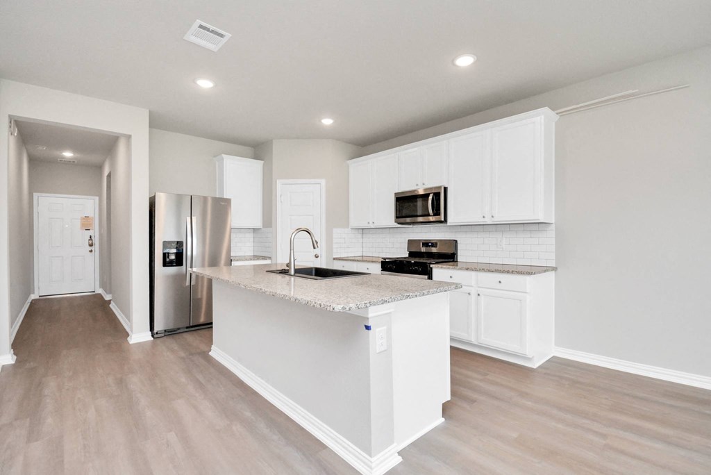 a kitchen with white cabinets and a large island