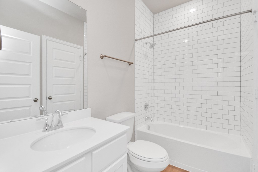 a bathroom with a white sink and toilet next to a bathtub with a shower curtain