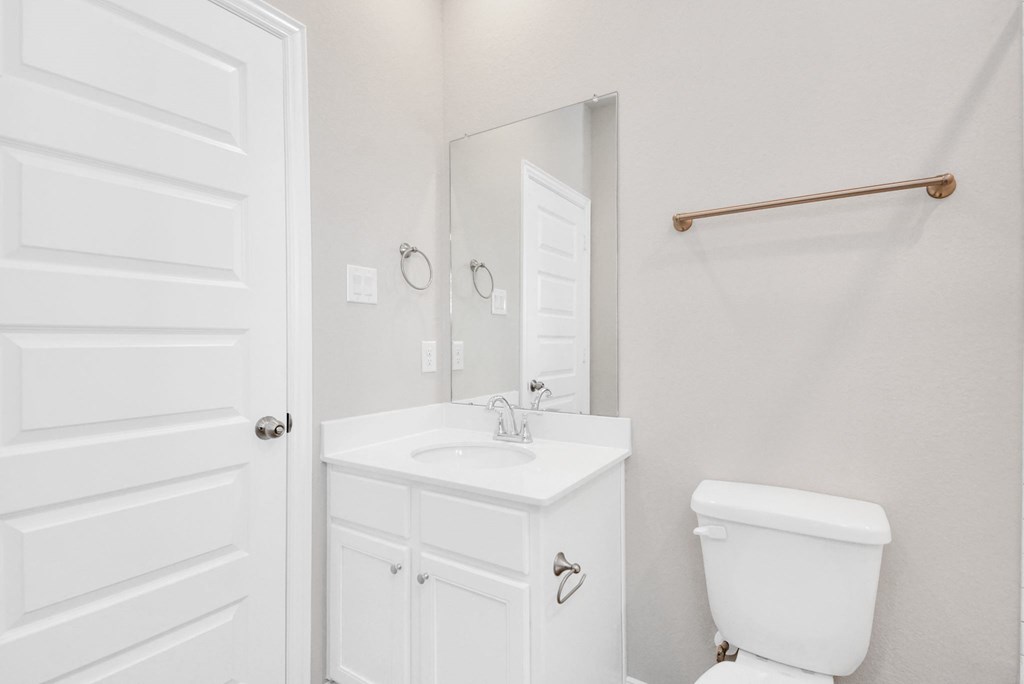 a bathroom with a sink toilet and mirror