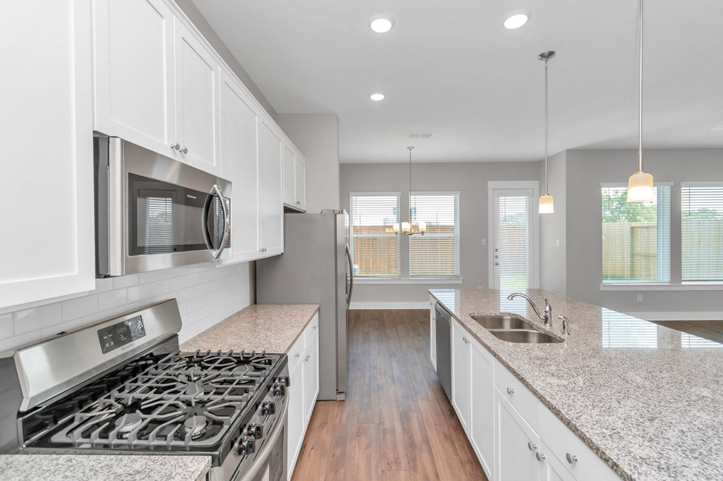 a kitchen with white cabinets and granite countertops