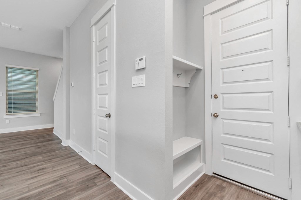 a walk in closet in a bedroom with a door to a closet and a window