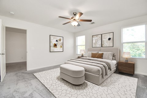 A bedroom with a large bed and a ceiling fan.