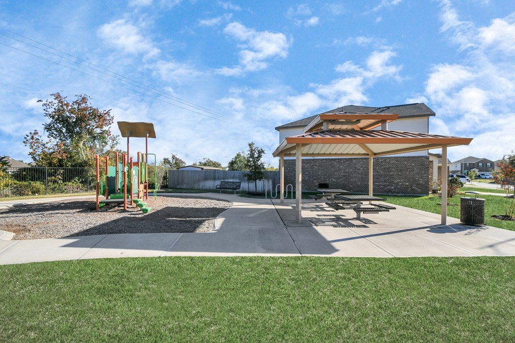 A playground with a swing set and a picnic pavilion.