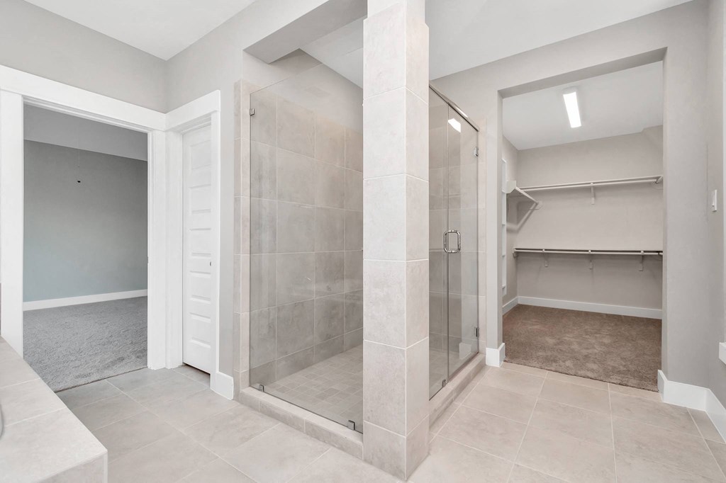 a large walk in shower with tiled walls and floors