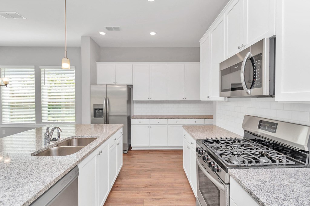 Heights, Houston TX Rental Homes - The Crossing at Timbergrove - Modern Kitchen with Granite Countertops, Stainless Steel Appliances, Expansive White Cabinetry, Hanging Lights, Dual Sink, Nearby Windo