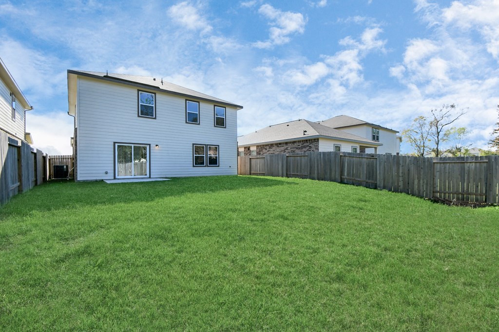 A white house with a green lawn in front of it.
