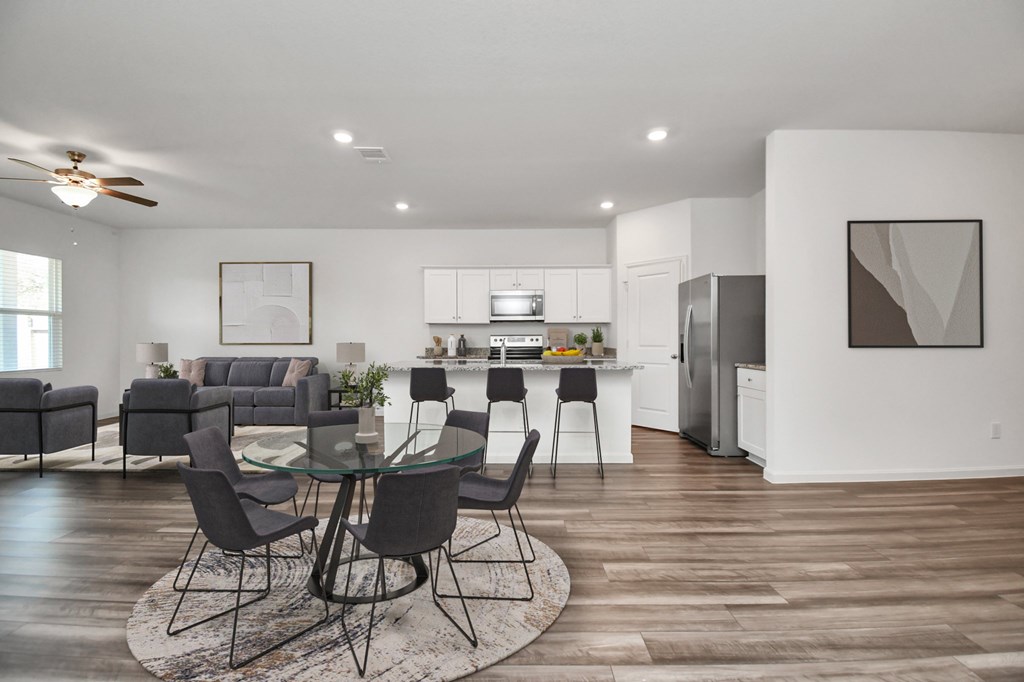 A modern kitchen with a dining table set in the middle of the room.
