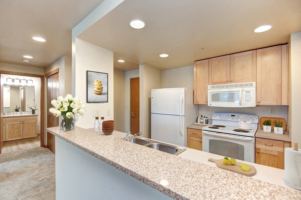a kitchen with white appliances and wooden cabinets