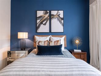 a bedroom with blue walls and a bed with pillows