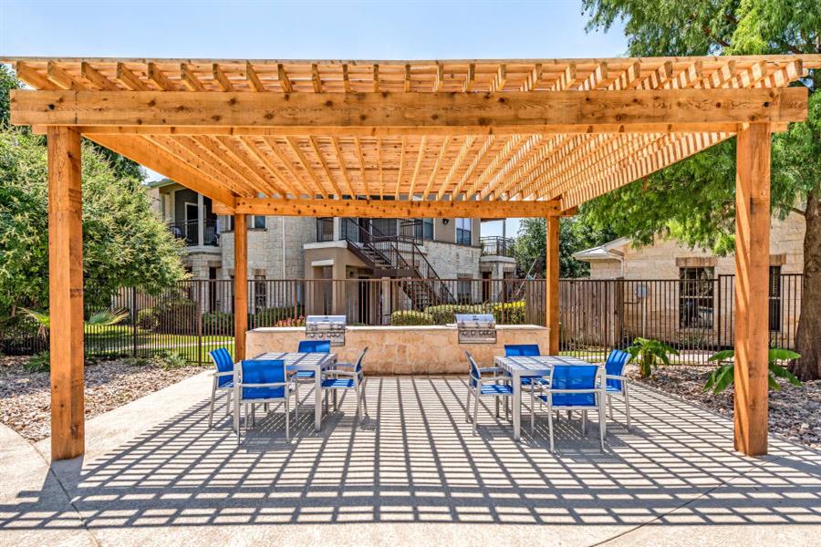 Pet-Friendly Apartments in Grand Prairie, TX - Forum at Grand Prairie - Picnic Area with Two BBQ Stations and Two Dining Areas Under a Pergola