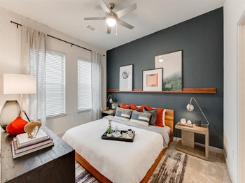 Apartments Grapevine - Stylish Bedroom With Dark Gray Accent Wall and Three White Walls, Two Large Windows, Silver Ceiling Fan, and Modern Furnishings - Photo Gallery 6