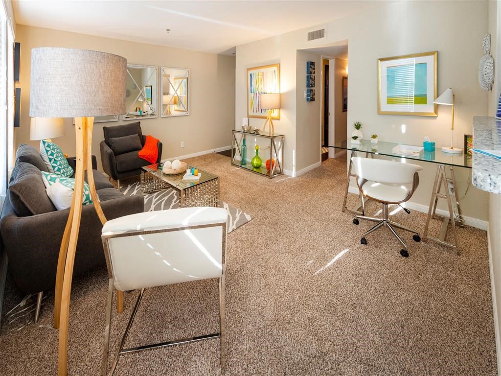 a living room with a couch and a chair and a desk