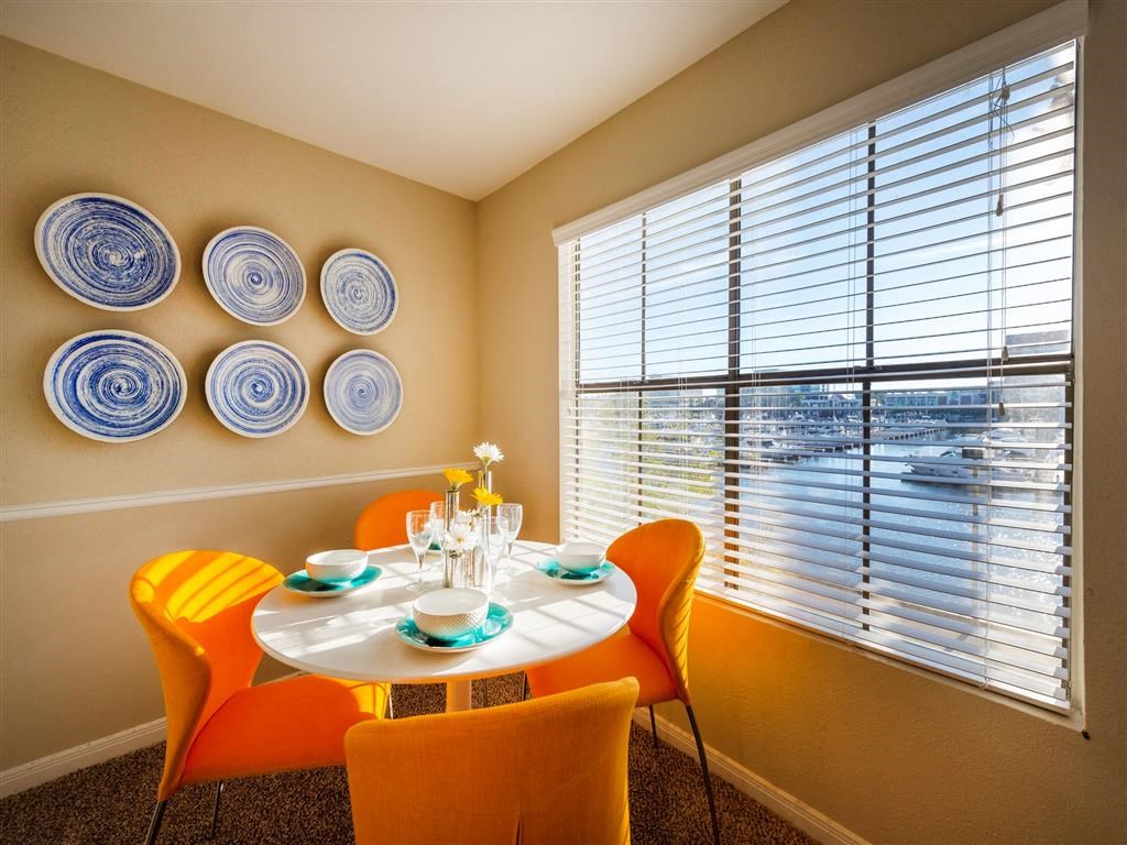 a dining room with a table and chairs and a large window