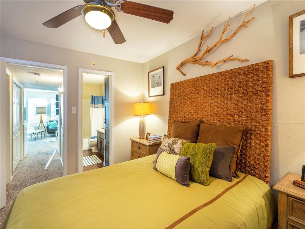 2 BR Apartments in League City, TX - Anchor at South Shore - Bedroom with Designer Ceiling Fan, Two Nightstands, and Private Bathroom