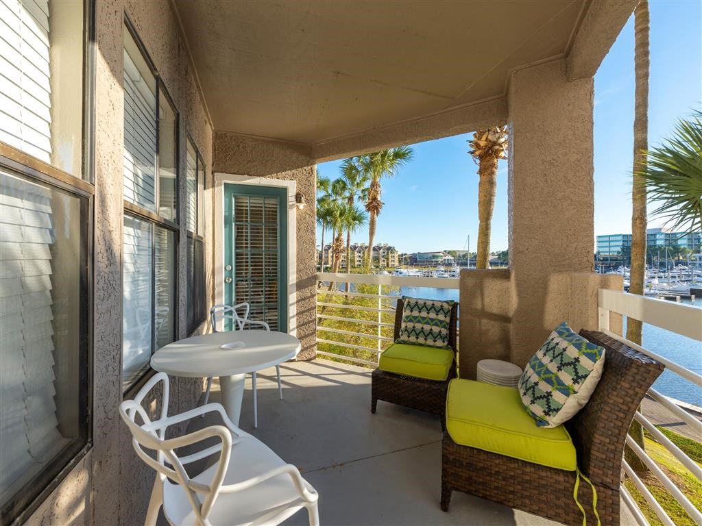a patio with a table and chairs and a body of water