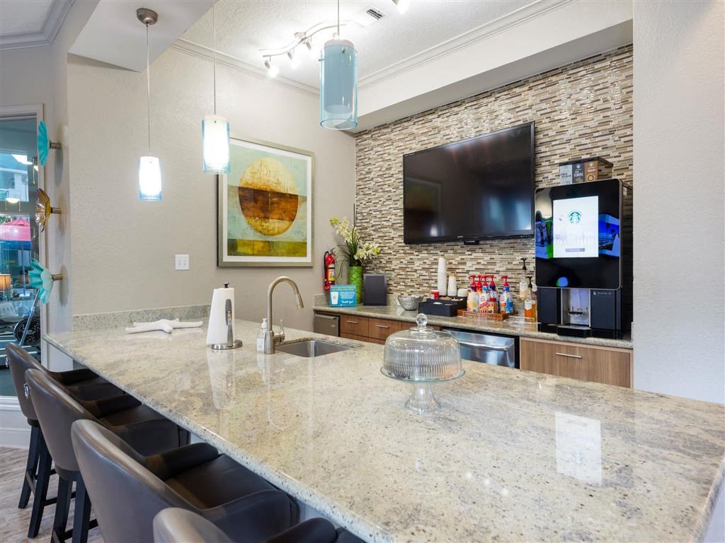 a kitchen with a marble counter top and a tv