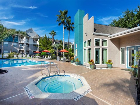 a swimming pool with a hot tub in front of a building