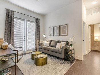 Apartments for Rent in Rowlett TX - Village of Rowlett - Living Room with Wood-Style Flooring and Entrance to Private Patio - Photo Gallery 11