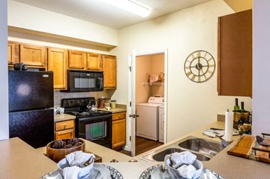 Apartments San Antonio TX - Club at Stone Oak Spacious Kitchen with Wooden Cabinetry, Fully Equipped with Black Appliances, and Much More