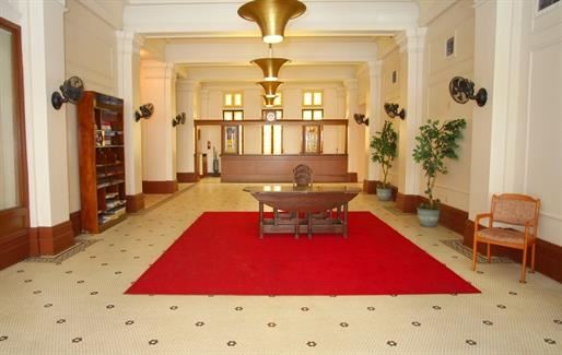 a lobby with a red rug and a table