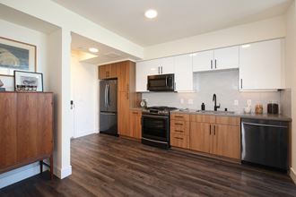 Berkeley CA Apartments - The Addison - Kitchen with Wood-Style Flooring, Wood-Style and White Cabinets, and Stainless-Steel Appliances