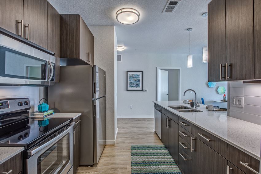 an open kitchen with stainless steel appliances and white countertops