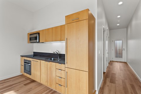 A kitchen with wooden cabinets and a microwave above the stove.