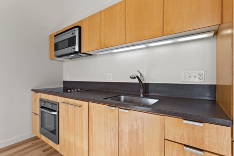 A kitchen with wooden cabinets and a black countertop.