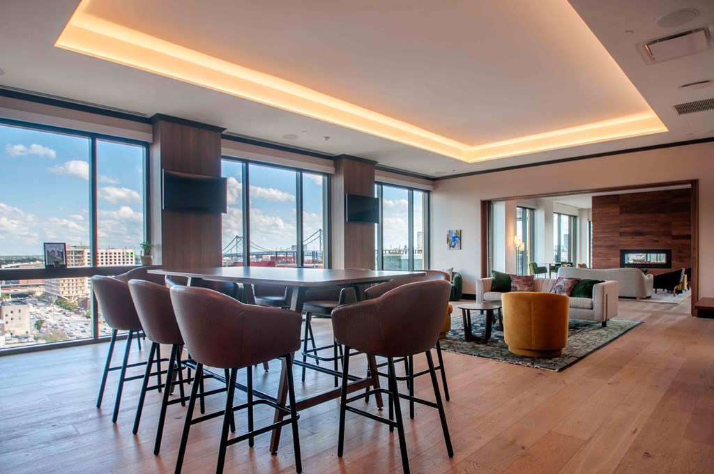 a dining room with a table and chairs and a living room with large windows