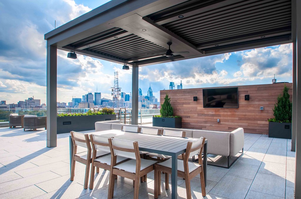 a terrace with a table and chairs and a view of the city