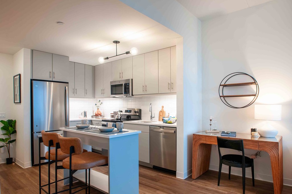 a kitchen with a blue island and a stainless steel refrigerator