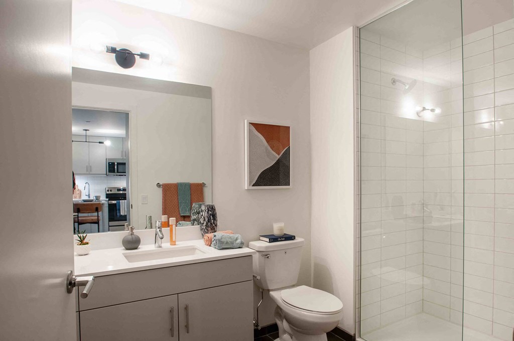 a bathroom with a toilet sink and shower and a mirror