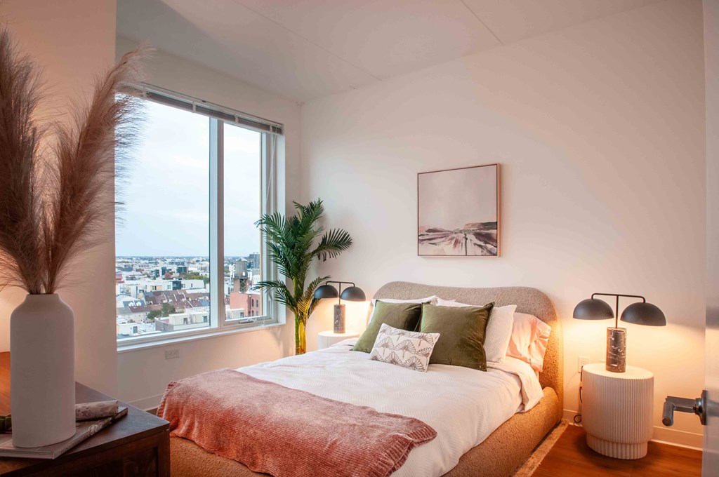 a bedroom with a bed and a large window