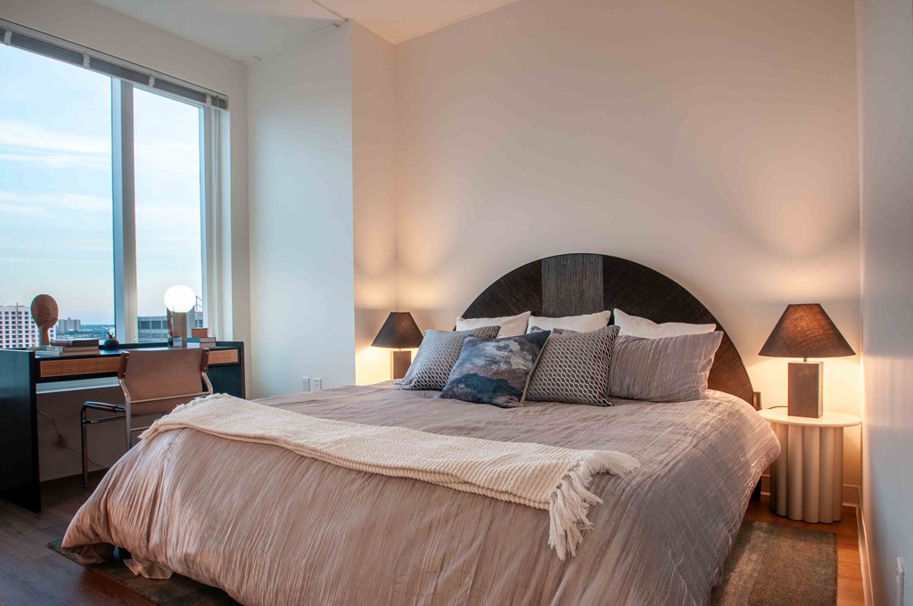 a bedroom with a bed and a large window