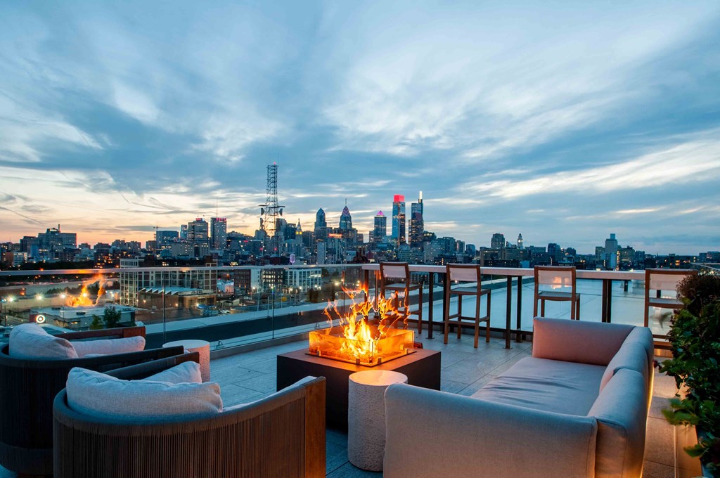 a view of the skyline from a rooftop bar with a fireplace