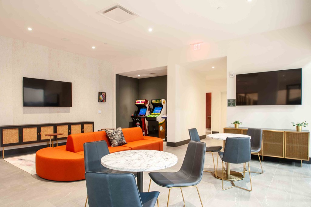 a living room with an orange couch and a table with chairs