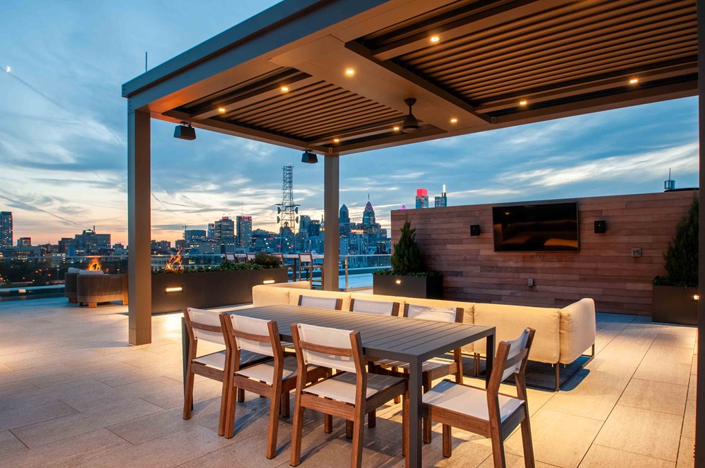 a terrace with a table and chairs and a view of the city