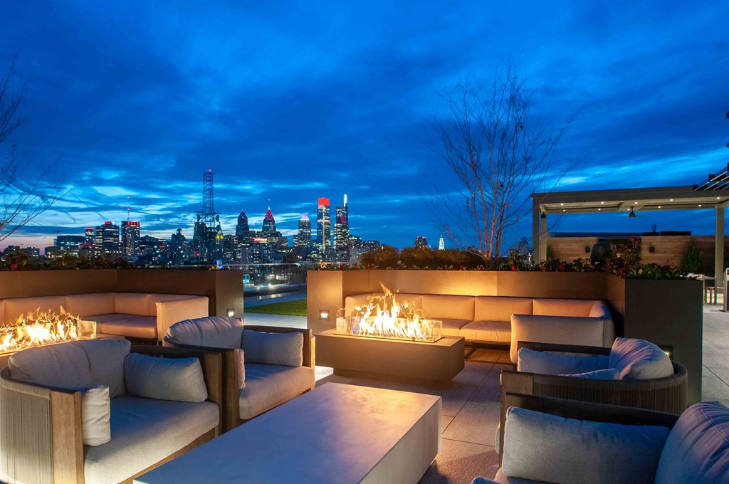 a view of the city from a rooftop patio with couches and a fireplace