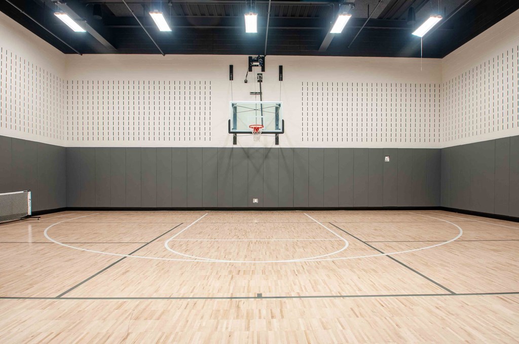 a basketball court in a gymnasium with a basketball hoop