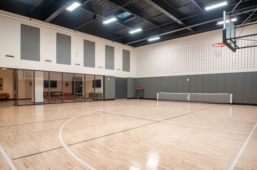 a basketball court in a gym with a basketball hoop
