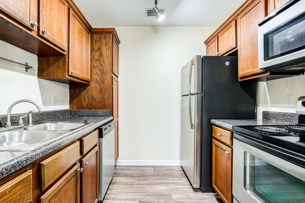 Kitchen with stainless steel appliances and ample cabinet space at The Commons, a pet-friendly community in Tampa, FL, near Temple Terrace.