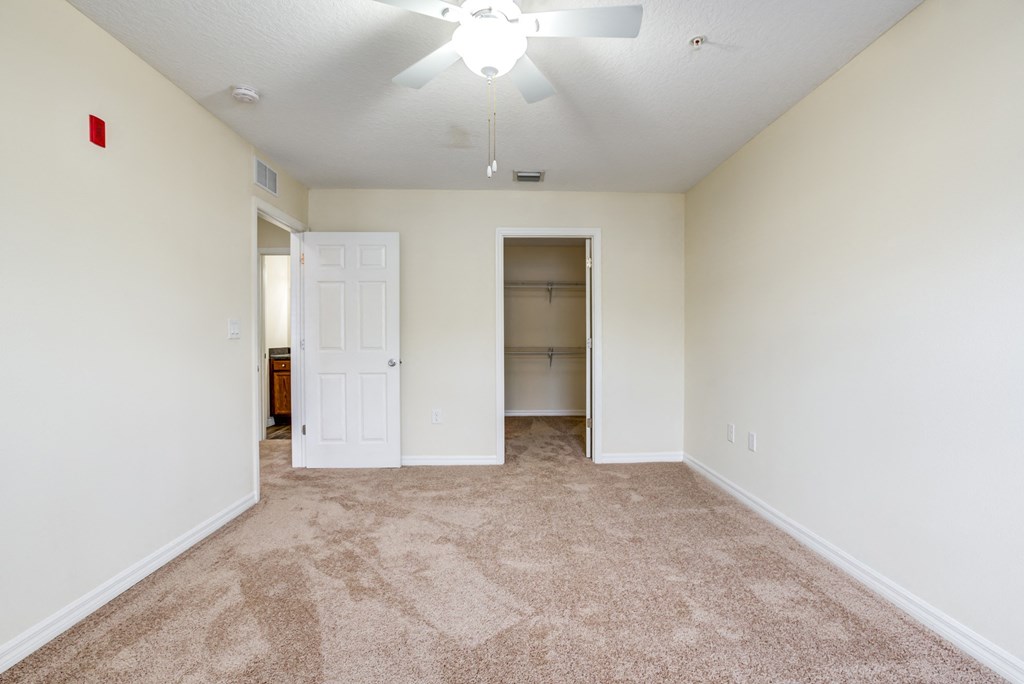 Bedroom with carpet, large closet, and ceiling fan at The Commons, a pet-friendly community in Tampa, FL, near Temple Terrace.
