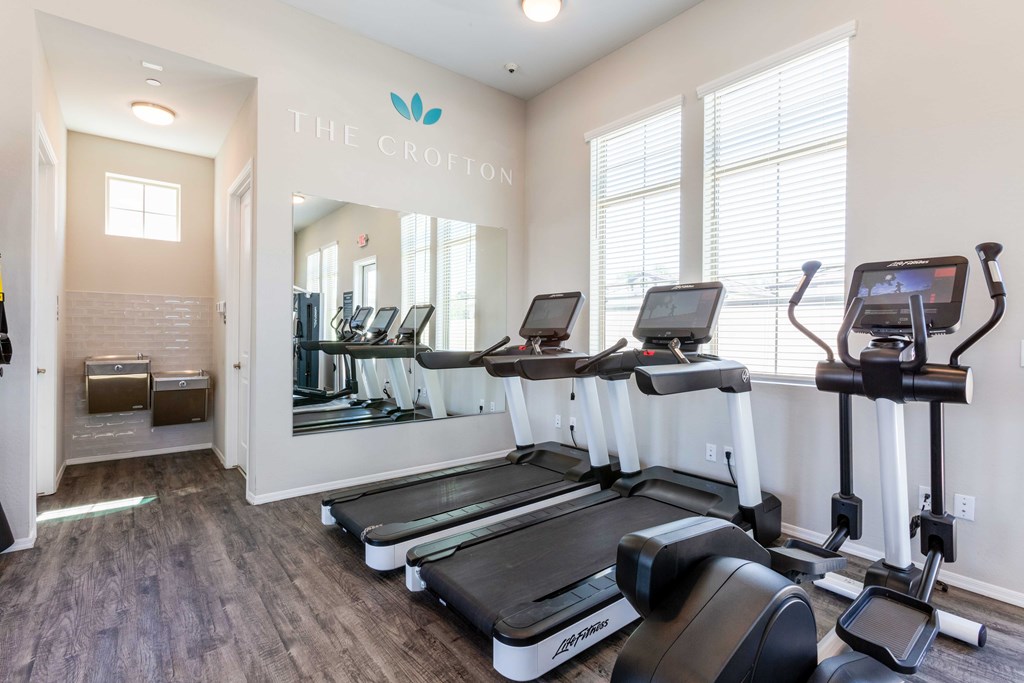 A gym with treadmills and elliptical machines.