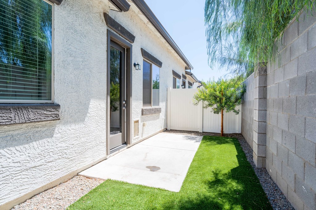 A modern house with a white exterior and a small garden area.