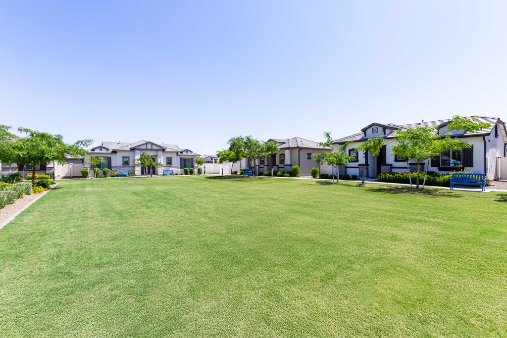 A row of houses with a green lawn in front.