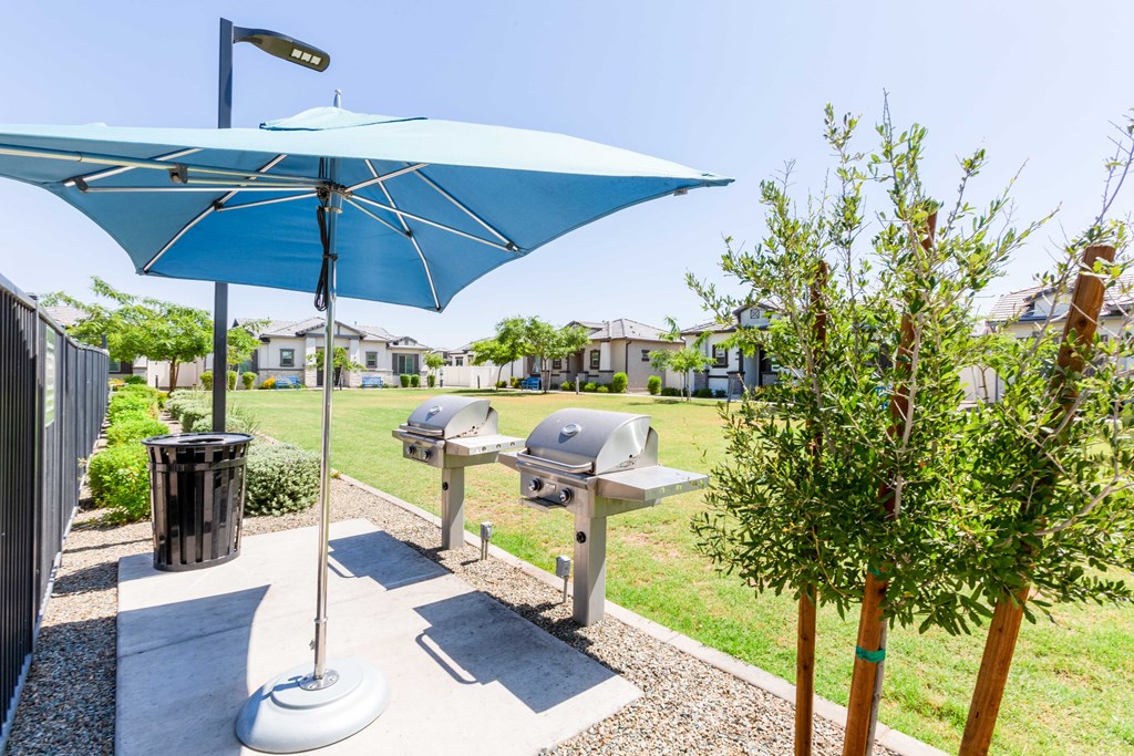 A blue umbrella is open over a picnic table.