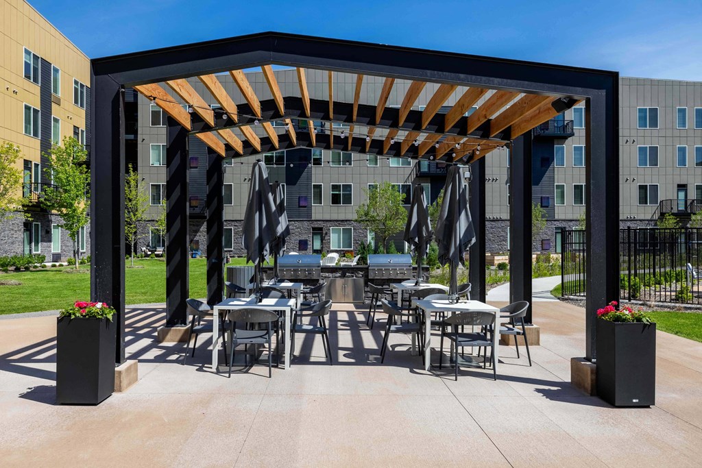 a patio with tables and chairs and awning