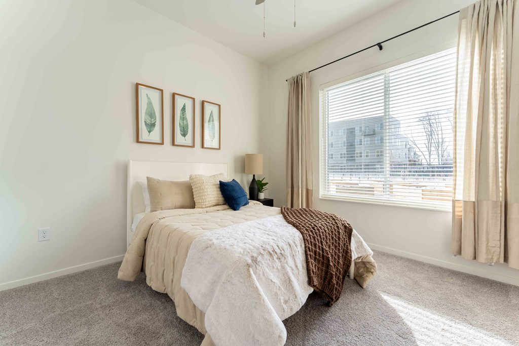 a bedroom with a bed and a large window