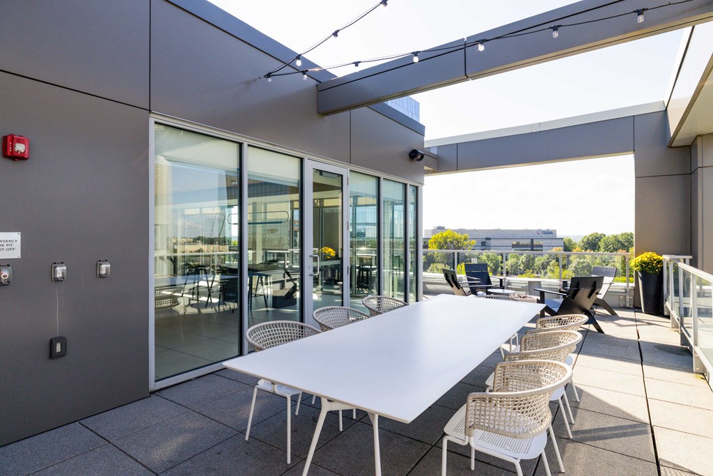 A white table with chairs is set up on a patio.