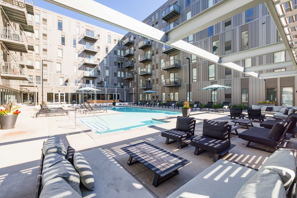 A large outdoor pool area with lounge chairs and umbrellas.